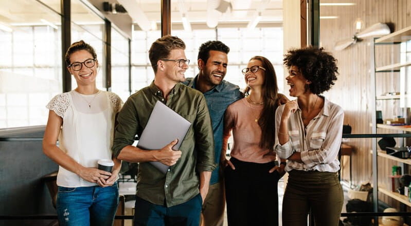 Diverse black and white young business people laughing and smiling together.